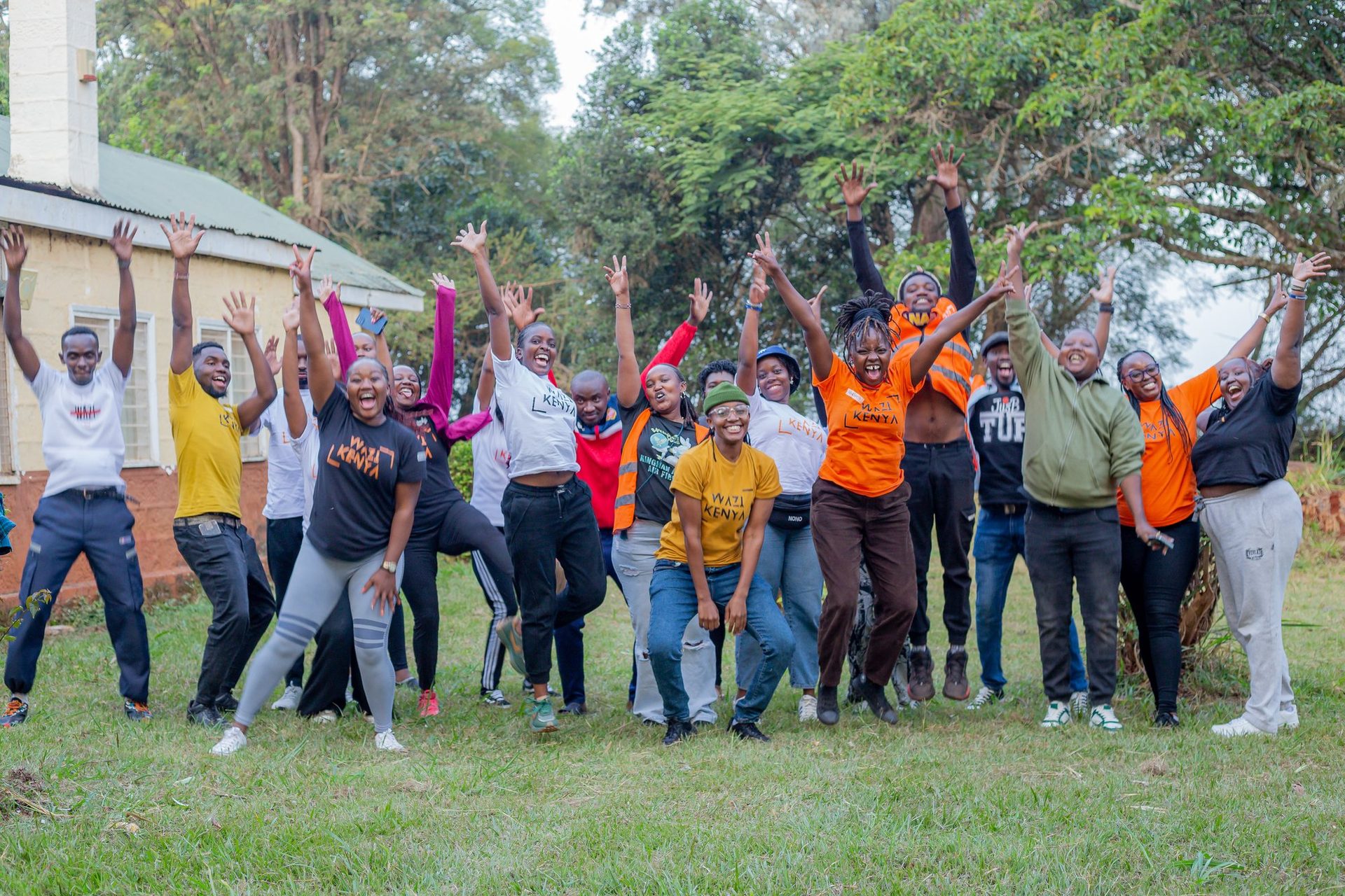 The Wazi team mid-jump, arms up, after an AGM session.